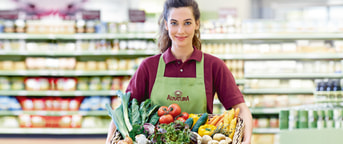Une employée chez Alnatura porte un panier de légumes Une employée chez Alnatura porte un panier de légumes